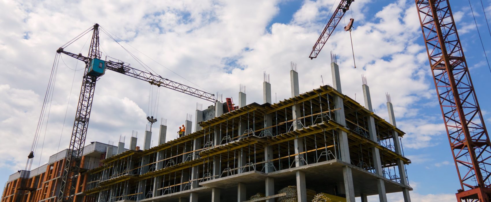 Tower crane at high concrete residential building under construction. Real estate development concept. Tower crane at high concrete residential building under construction. Real estate development concept.